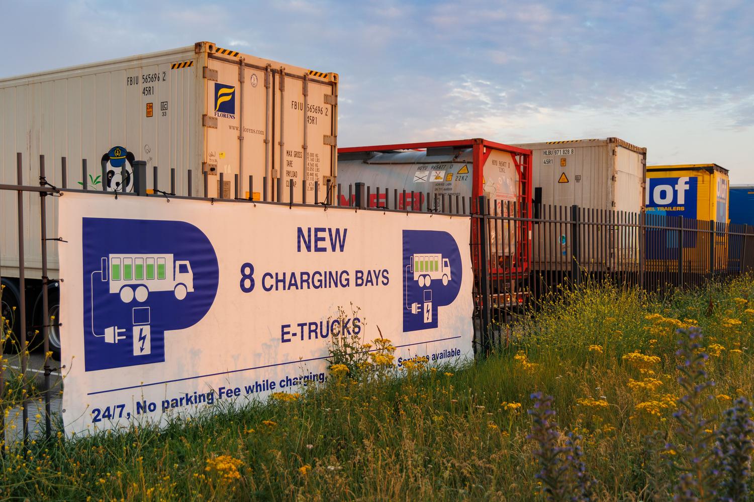 Centro de carga para camiones eléctricos de gran tonelaje en un núcleo logístico, destacando el transporte de carga sostenible.
