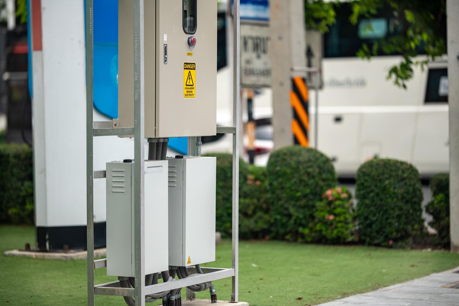 Estación de recarga de vehículos eléctricos moderna en un entorno urbano sostenible, ilustrando la electrificación de la movilidad.