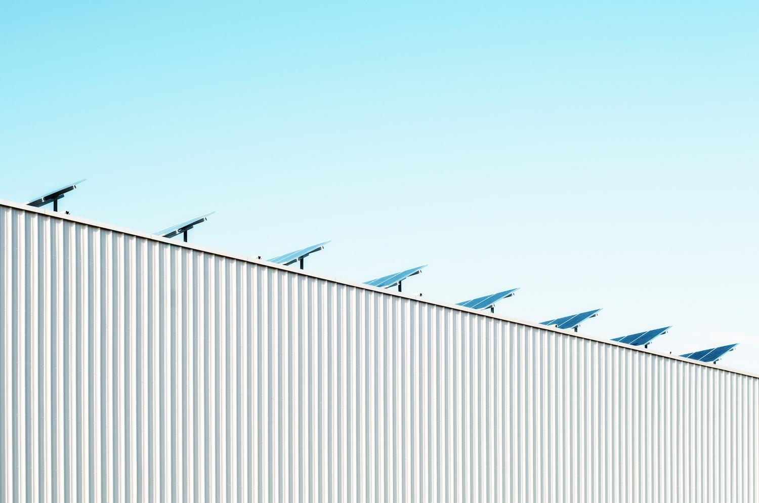 Paneles solares sobre la cubierta de un edificio comercial, representando la transición energética en pymes y comercios.