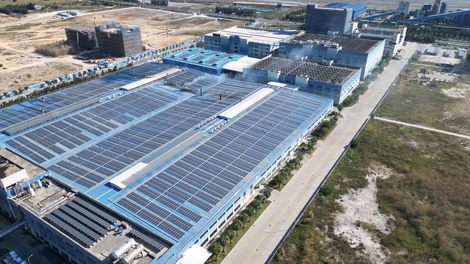 Vista aérea de paneles solares instalados en el techo de un complejo industrial, representando la maximización de activos y el ROI industrial. Vista aérea de paneles solares instalados en el techo de un complejo industrial, representando la maximización de activos y el ROI industrial.