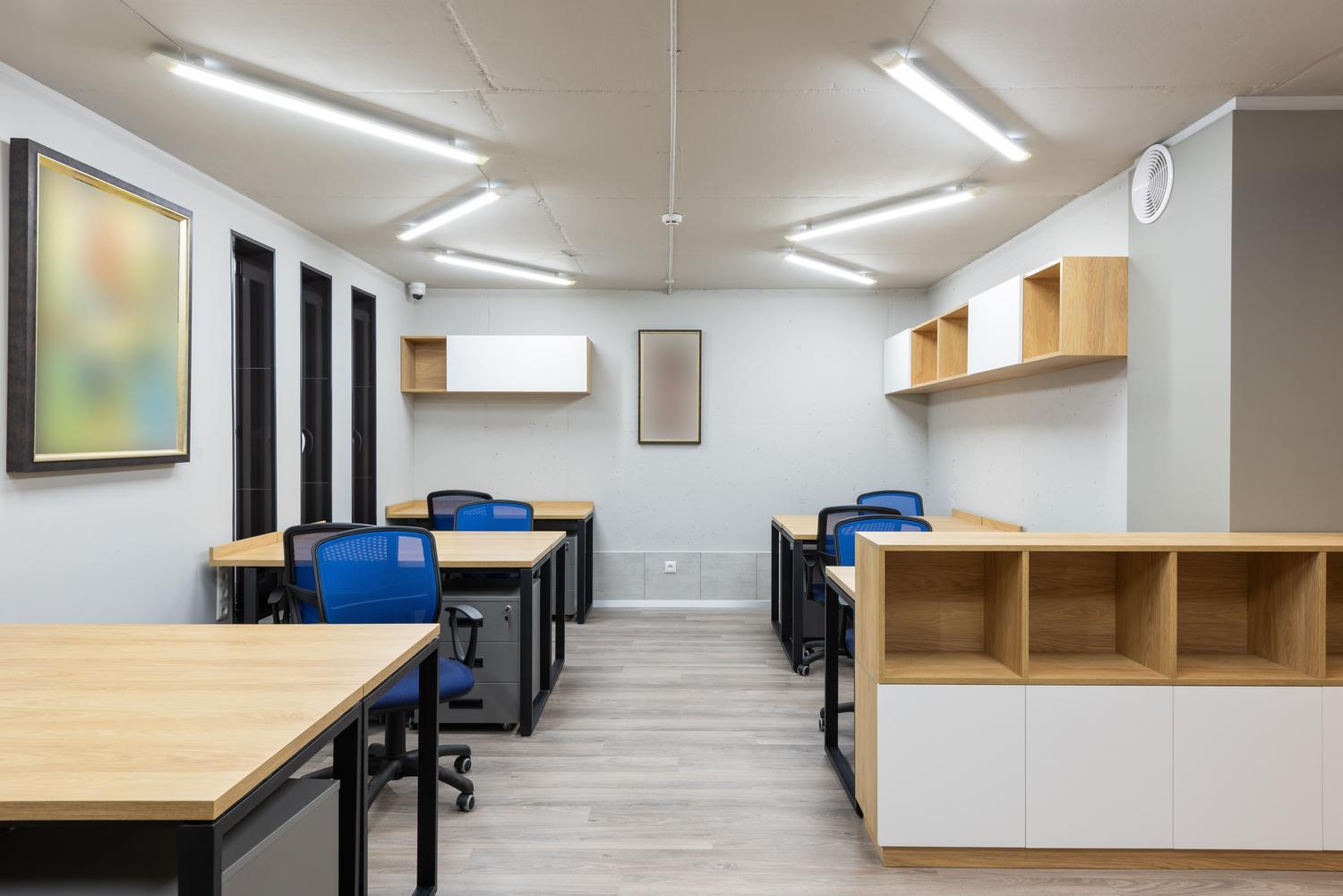 Interior de una oficina moderna con iluminación LED lineal eficiente y diseño sostenible.