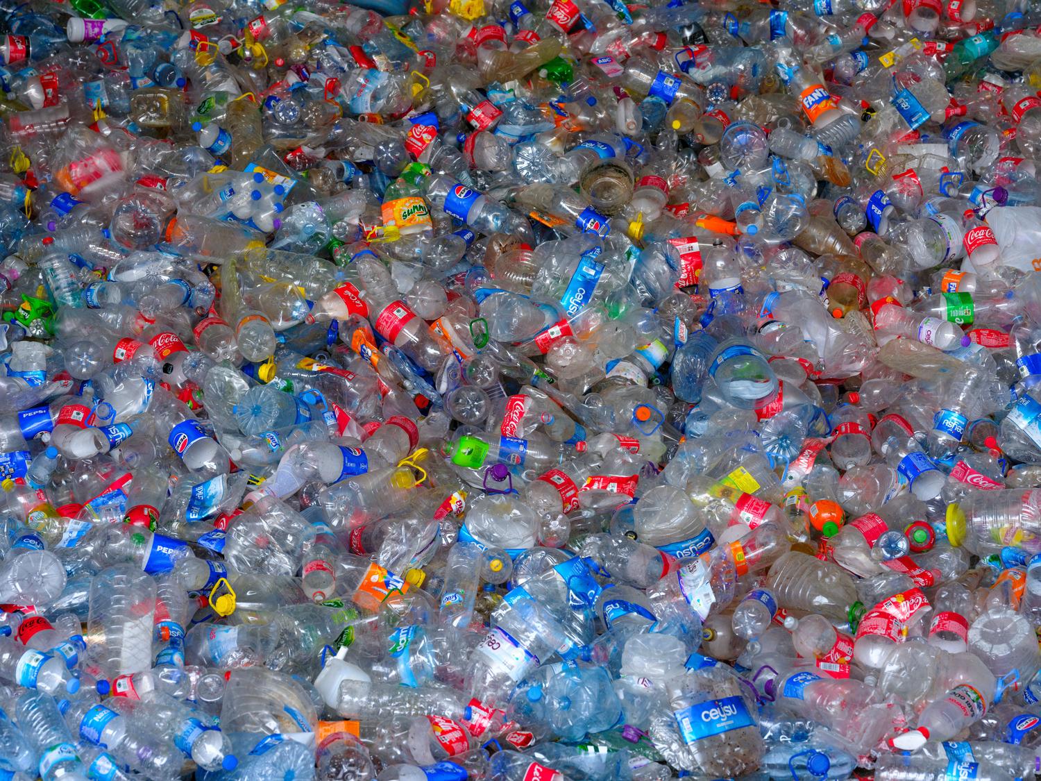 Montón de botellas de plástico desechadas, simbolizando el concepto de vehículos que nacen de los residuos.