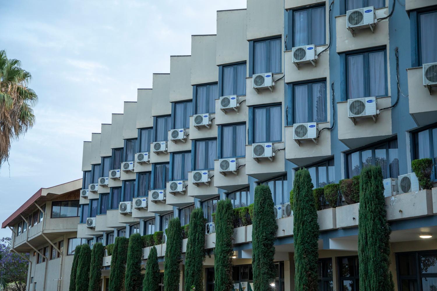 Vista exterior de un edificio hotelero con unidades de aire acondicionado tradicionales, ilustrando la infraestructura antes de la transición inteligente.