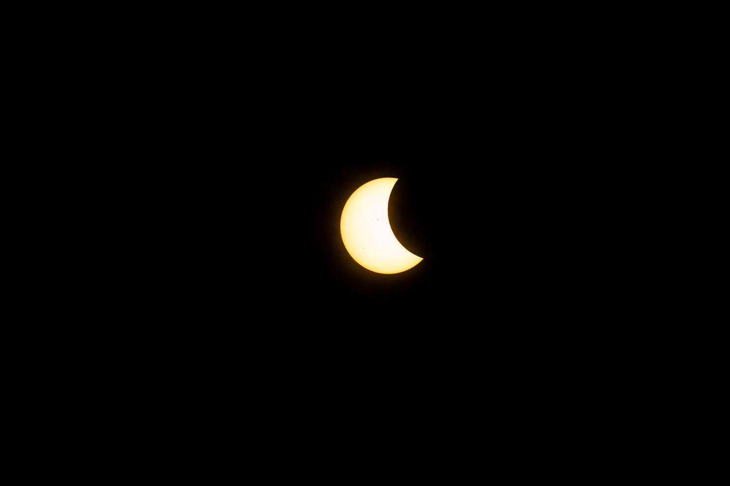 Eclipse solar parcial donde la Luna cubre una parte del disco solar dejando una brillante forma de medialuna.