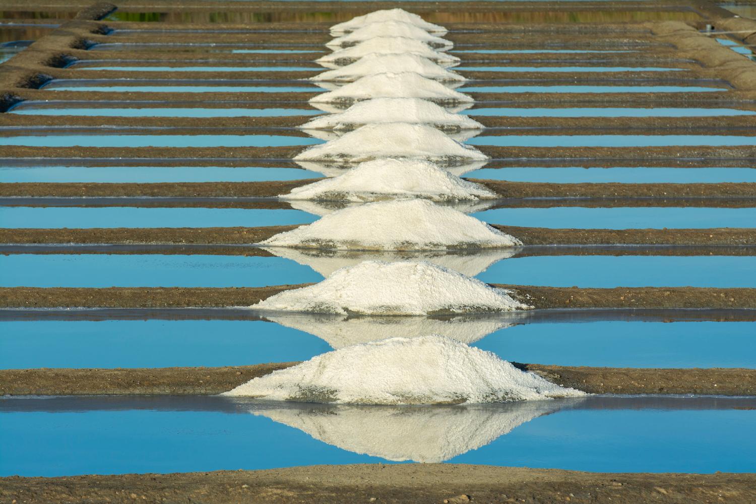 Salinas tradicionales de Guérande en Francia con montículos de sal blanca, representando la importancia de la explotación sostenible.