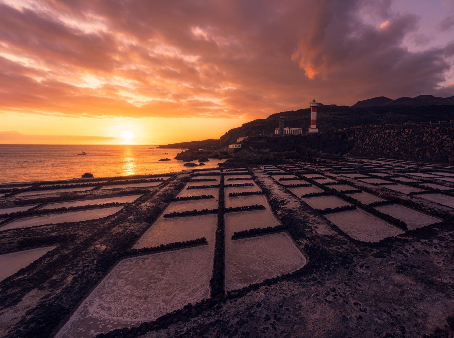 Paisaje al atardecer de las Salinas de Fuencaliente con su característica cuadrícula de balsas de evaporación volcánicas.