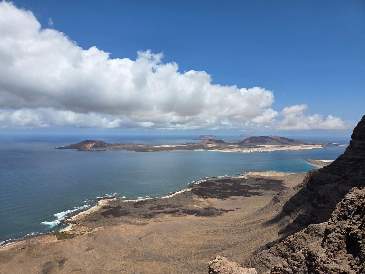 Costa volcánica de Lanzarote con un fuerte contraste entre la lava negra solidificada y el azul intenso del mar.