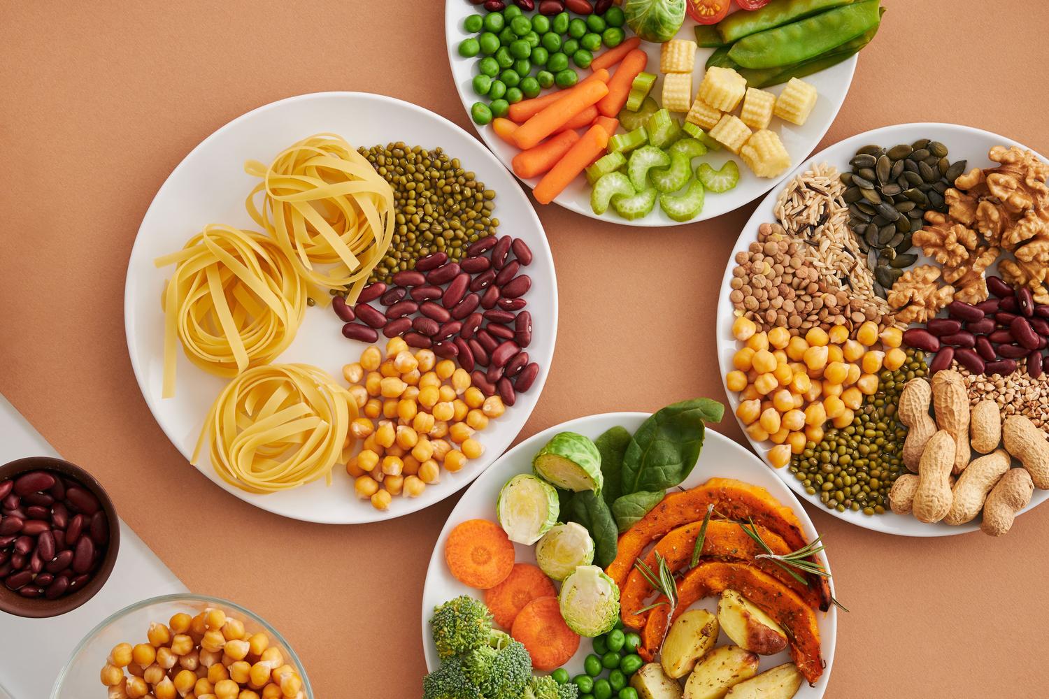 Variedad de alimentos ricos en proteínas vegetales, incluyendo legumbres, frutos secos y semillas, dispuestos de forma saludable.