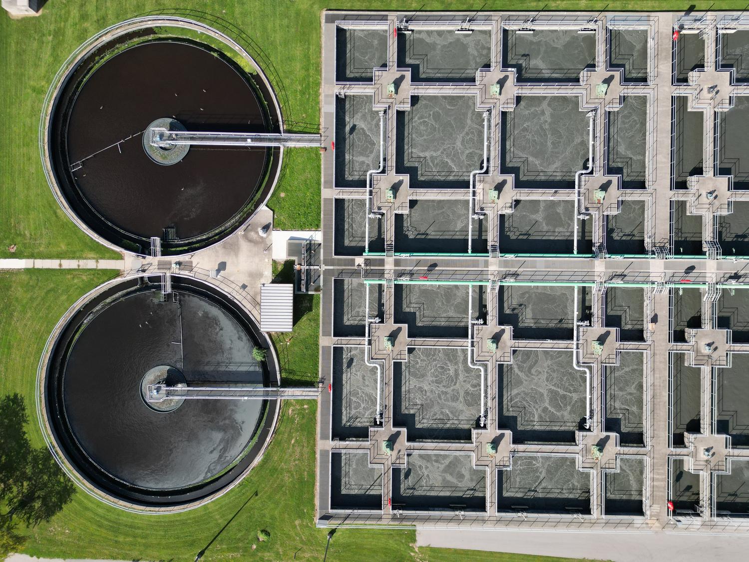 Vista aérea de una planta de tratamiento de aguas residuales moderna con tanques de filtración y procesos de aireación.