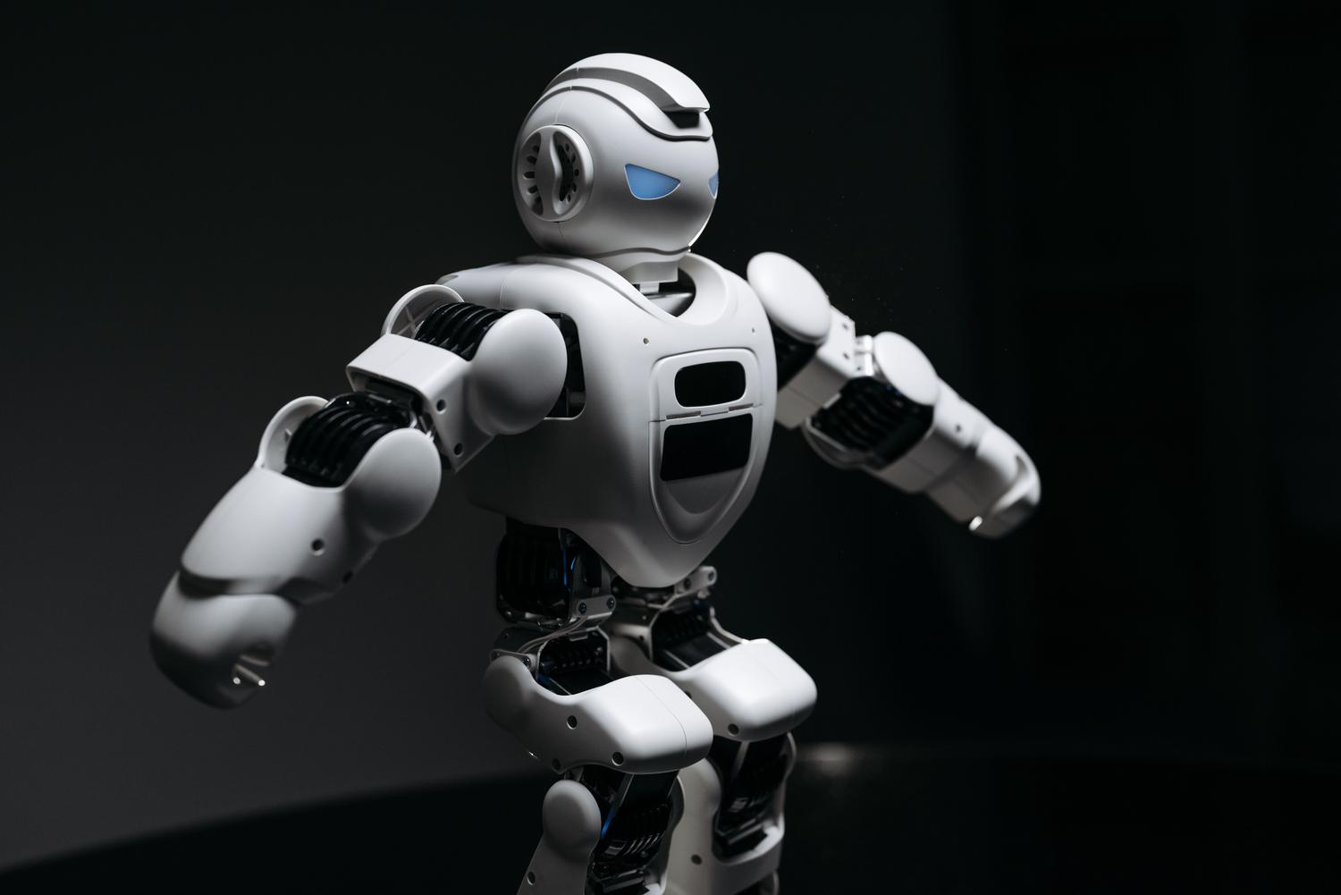 Robot humanoide de diseño avanzado con iluminación dramática que resalta su estructura mecánica.