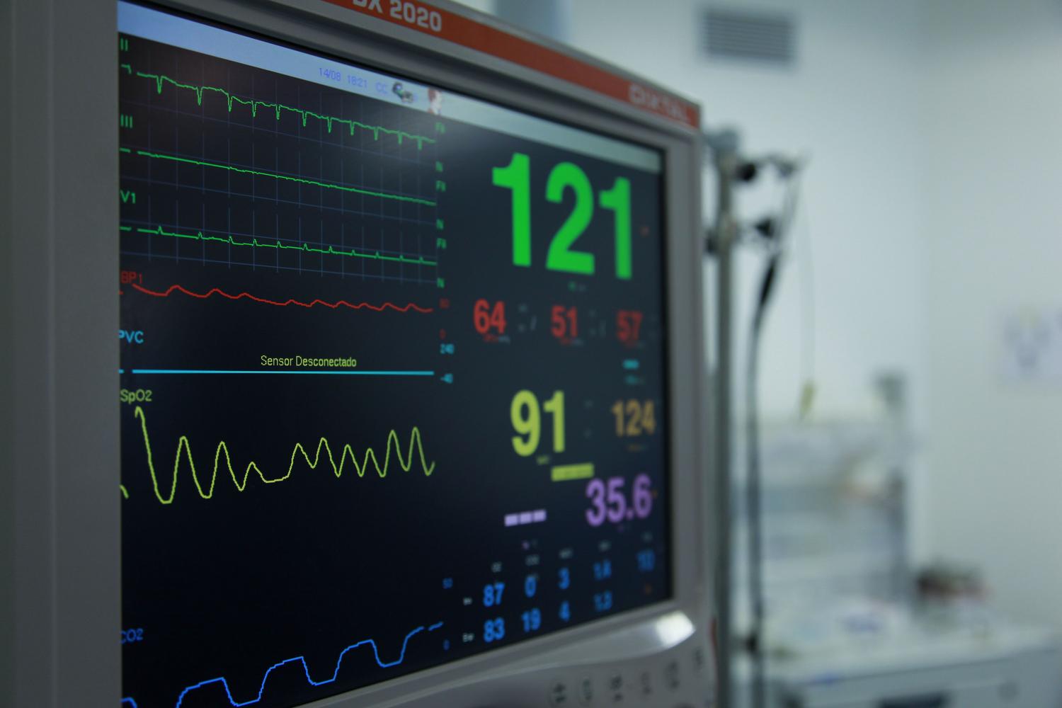 Primer plano de un monitor de signos vitales, representando la eficiencia técnica y la monitorización de datos por IA.