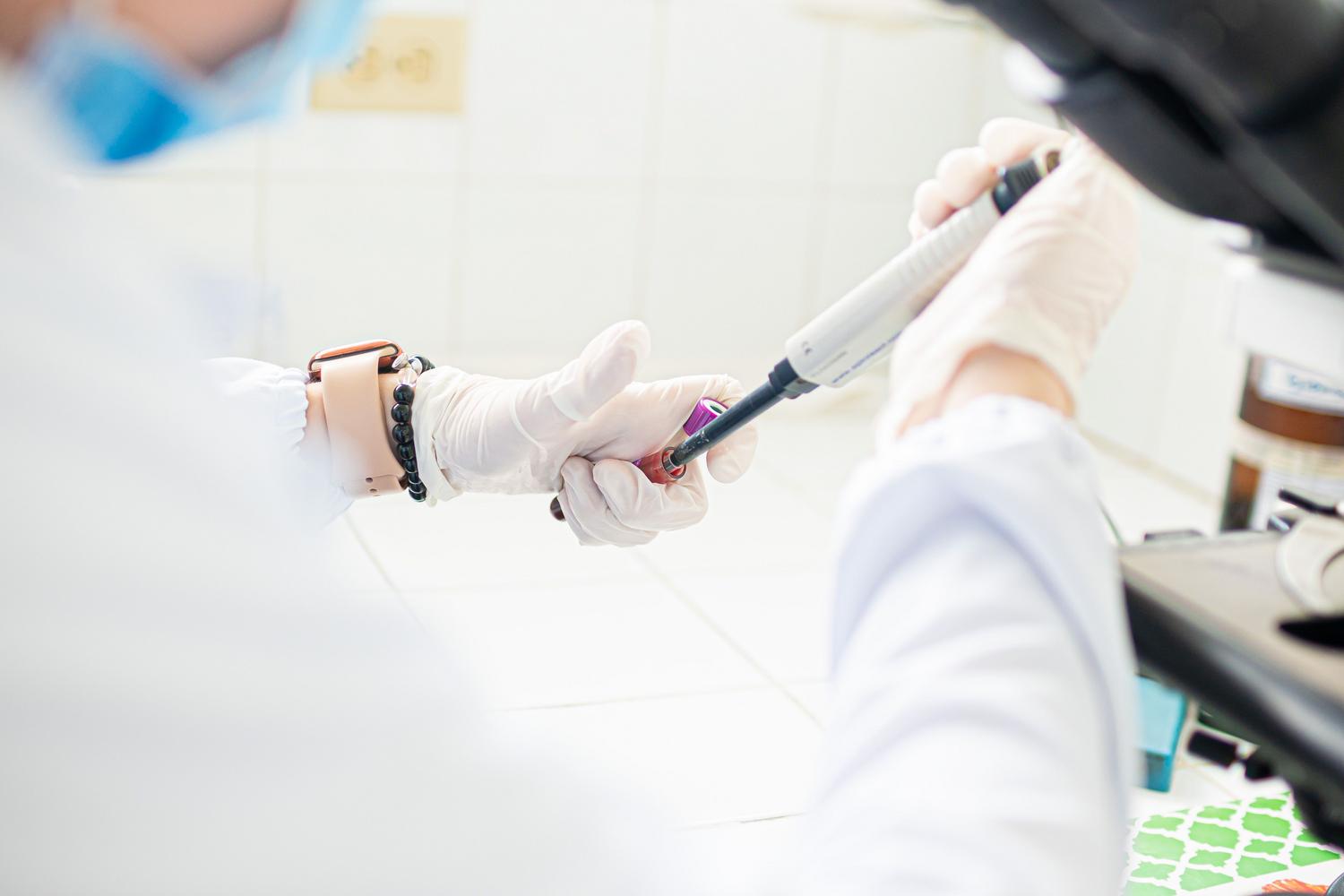 Profesional de laboratorio utilizando una pipeta para el análisis de muestras genéticas.