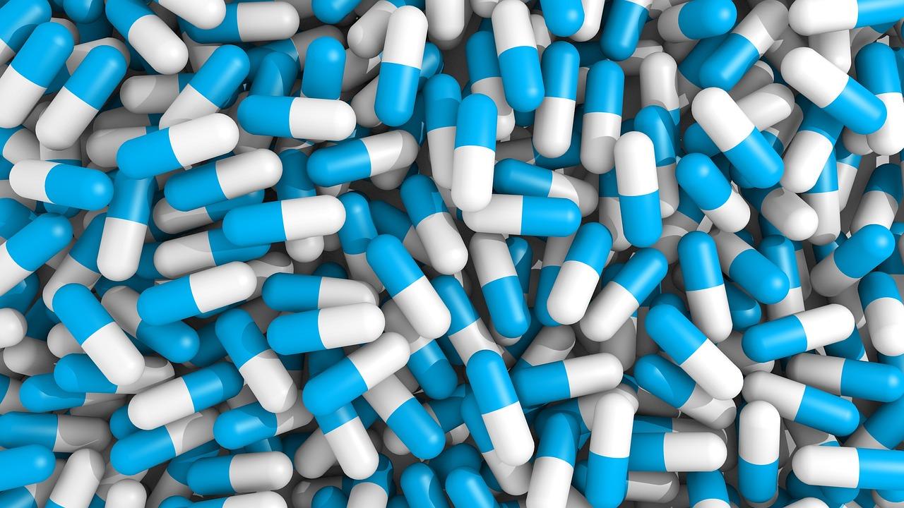 Fotografía de pastillas y comprimidos genéricos sobre un fondo neutro, representando la medicación farmacológica.