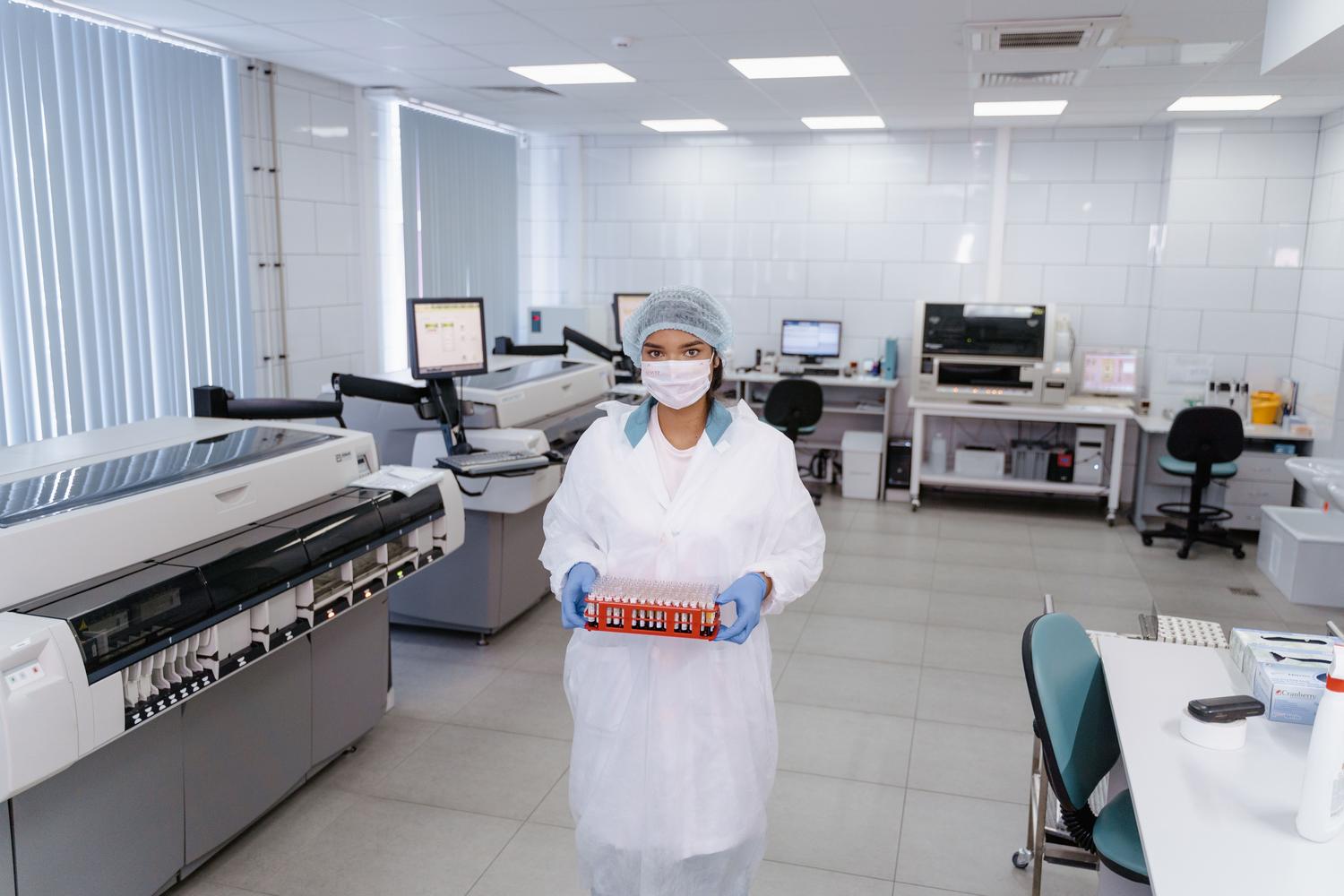 Profesional de laboratorio manipulando muestras sanguíneas, simbolizando la medicina de precisión y el análisis genético.
